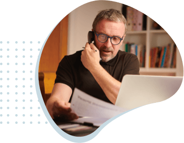 Man on the phone reviewing paperwork.