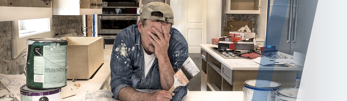 Man painting home covers face with palm