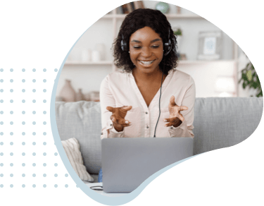 Woman on couch communicating on laptop.