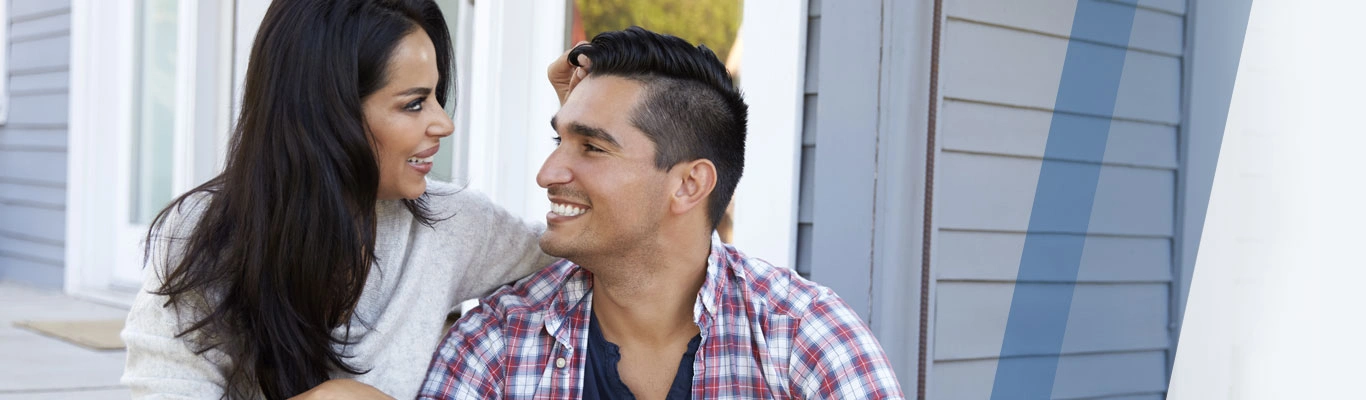 Smiling Hispanic couple on porch