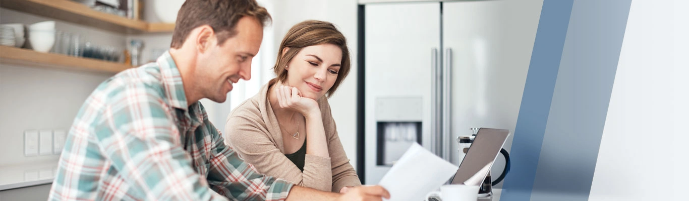 Couple with paperwork and laptop in kitchen